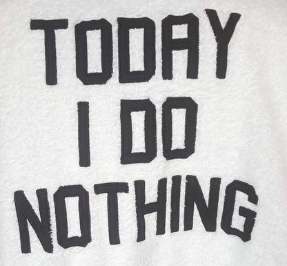 Zwarte tekst 'TODAY I DO NOTHING' op een witte achtergrond, mogelijk een badjas of kledingstuk.
