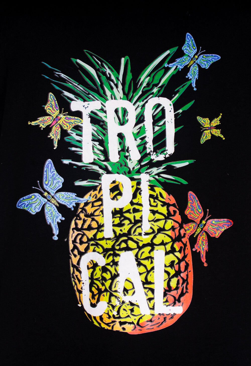 Zwart nachthemd met kleurrijke ananas en vlinders, tekst 'TROPICAL' in wit tegen donkere achtergrond.